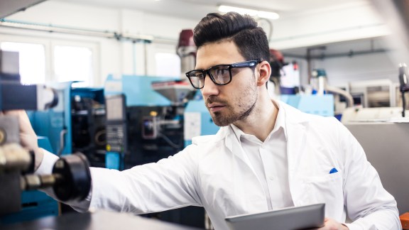 Young engineer holding digital tablet in the factory