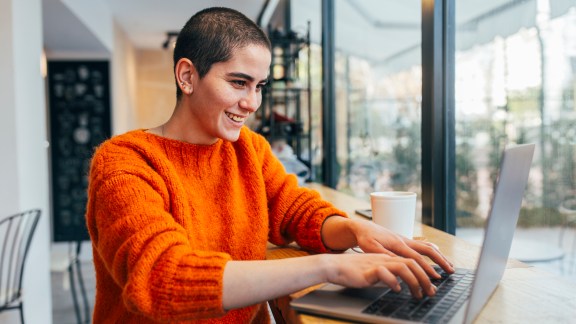 Portrait of happy and young bald woman smiling. Carefree girl with bald head after cancer chemotherapy treatment.