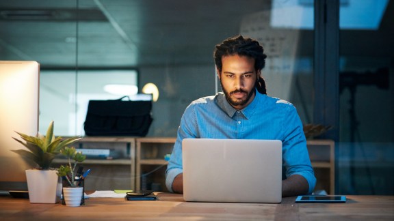 Cropped shot of a young designer working late on a laptop in an office