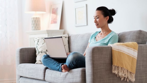 Japanese woman using laptop on sofa