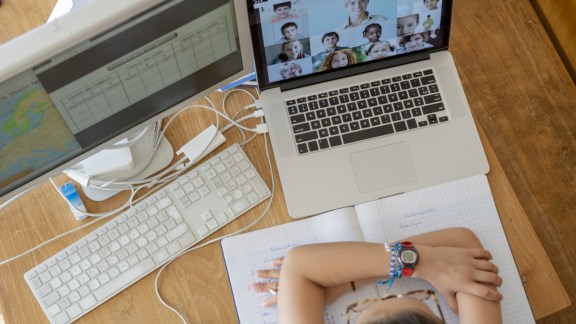 Overhead view of girl attending online school classes from home during coronavirus lockdown