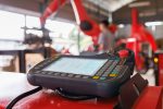 robot controller with blured engineer worker and red arm robot in automotive factory as background.