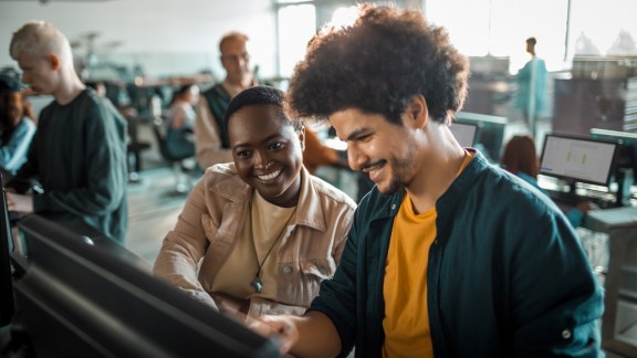 Close up of a group of students in the university working on their computers