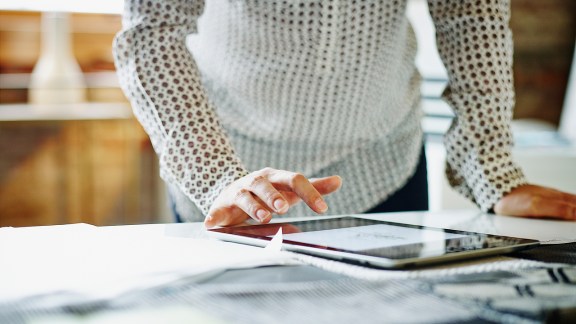 Businesswoman looking at digital tablet on table in office