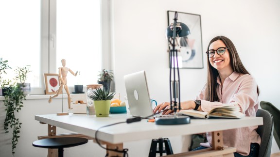 Beautiful young woman working at home. Freelance work. Creative industry. Domestic life. Home interior. Stock photography.