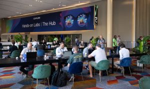 VMware Explore 2024 Las Vegas attendees in The Commons, in front of sign for The Hub and Hands-on Labs