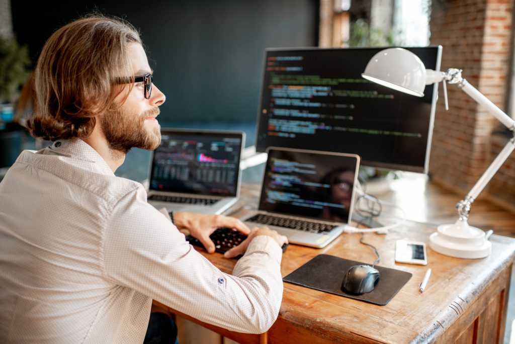 A person sitting at a desk with a computer and a lampDescription automatically generated with low confidence