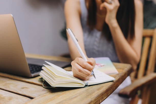 Female arm putting pen to paper.